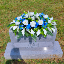 Load image into Gallery viewer, This Headstone Saddle has grave flowers including Cream Calla Lilies, Roses & royal blue filler. It is a perfect cemetery decoration.