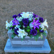 Load image into Gallery viewer, Headstone Saddle with purple & white trumpet lilies and purple roses. It is a grave flower cemetery, funeral, or memorial decoration.