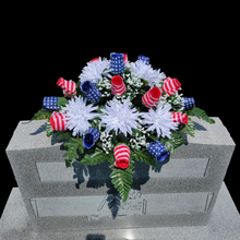 Load image into Gallery viewer, This Stars and Stripes Rosebud cemetery saddle decoration has grave flowers including stars and stripe rosebuds and White Spider Mums.