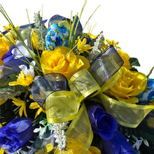Load image into Gallery viewer, Spring Headstone Saddle has blue, yellow, &amp; cream faux silk rose and calla lily grave flowers with floral print Easter eggs and ribbon.
