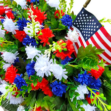 Load image into Gallery viewer, This Headstone Saddle has grave flowers including Red, White, &amp; Blue Mini Mums. It is a perfect Patriotic funeral or cemetery decoration.
