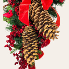 Load image into Gallery viewer, This is a teardrop door hanging that is festive for the Christmas season. It has pinecones, berries, pine, and a cardinal.
