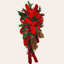 Load image into Gallery viewer, This is a teardrop door hanging that is festive for the Christmas season. It has pinecones, berries, pine, and a cardinal.
