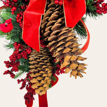 Load image into Gallery viewer, This is a teardrop door hanging that is festive for the Christmas season. It has pinecones, berries, pine, and a cardinal.
