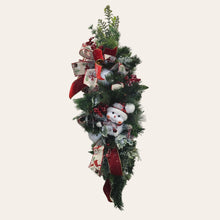 Load image into Gallery viewer, This is a teardrop door hanger that is a festive swag for Christmas season. It has berries, pinecone, snowballs, cute snowman, and a bow.
