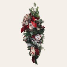 Load image into Gallery viewer, This is a teardrop door hanger that is a festive swag for Christmas season. It has berries, pinecone, snowballs, cute snowman, and a bow.
