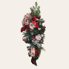 Load image into Gallery viewer, This is a teardrop door hanger that is a festive swag for Christmas season. It has berries, pinecone, snowballs, cute snowman, and a bow.
