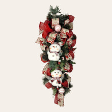 Load image into Gallery viewer, This teardrop door hanging wreath is a festive swag for the Christmas season. It has 2 snowmen, pine, berries, and 2 types of ribbon.
