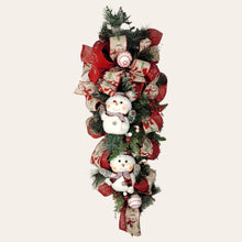 Load image into Gallery viewer, This teardrop door hanging wreath is a festive swag for the Christmas season. It has 2 snowmen, pine, berries, and 2 types of ribbon.
