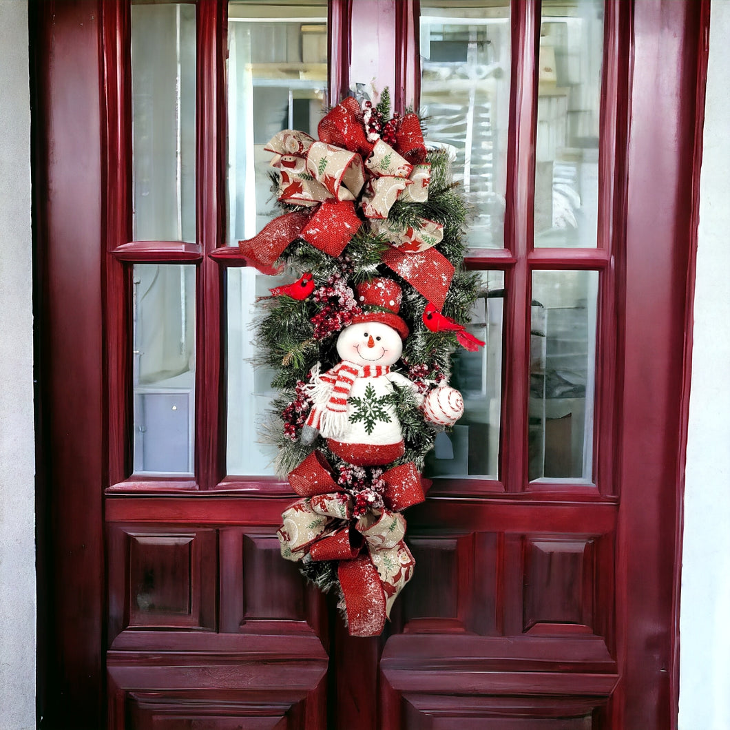 This is a teardrop door hanging that is festive for the Christmas season. It has a snowman, berries, cardinals, and 2 holiday bows.