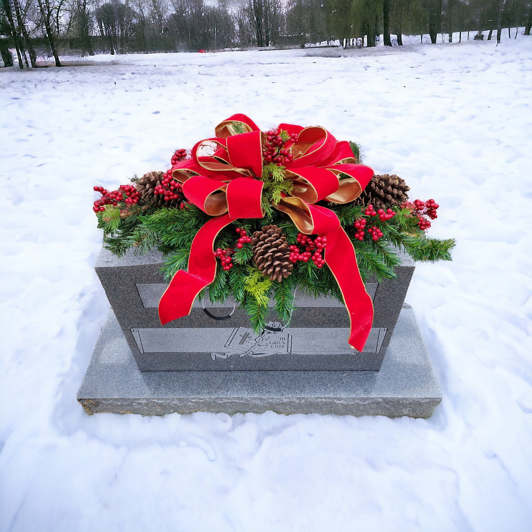 Christmas Cemetery Saddle has winter pine greenery, berries, and pinecones. This is a funeral or winter memorial decoration.