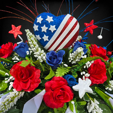 Load image into Gallery viewer, This headstone saddle is a patriotic cemetery decoration with grave flowers including red &amp; cream roses and large American flag heart.
