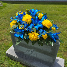 Load image into Gallery viewer, This Headstone Saddle has grave flowers including Vibrant Blue Trumpet Lilies, Bright Yellow Mums, &amp; Rosebuds. It is a memorial decoration.
