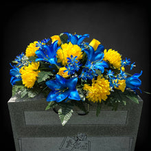 Load image into Gallery viewer, This Headstone Saddle has grave flowers including Vibrant Blue Trumpet Lilies, Bright Yellow Mums, &amp; Rosebuds. It is a memorial decoration.
