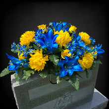 Load image into Gallery viewer, This Headstone Saddle has grave flowers including Vibrant Blue Trumpet Lilies, Bright Yellow Mums, &amp; Rosebuds. It is a memorial decoration.
