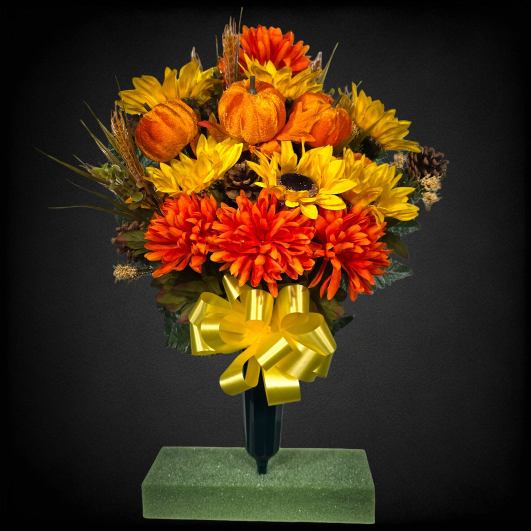 A cemetery cone with grave flowers including sunflower, mum, pumpkin, and wheat. This is a memorial decoration or flowers for funeral. (Copy)