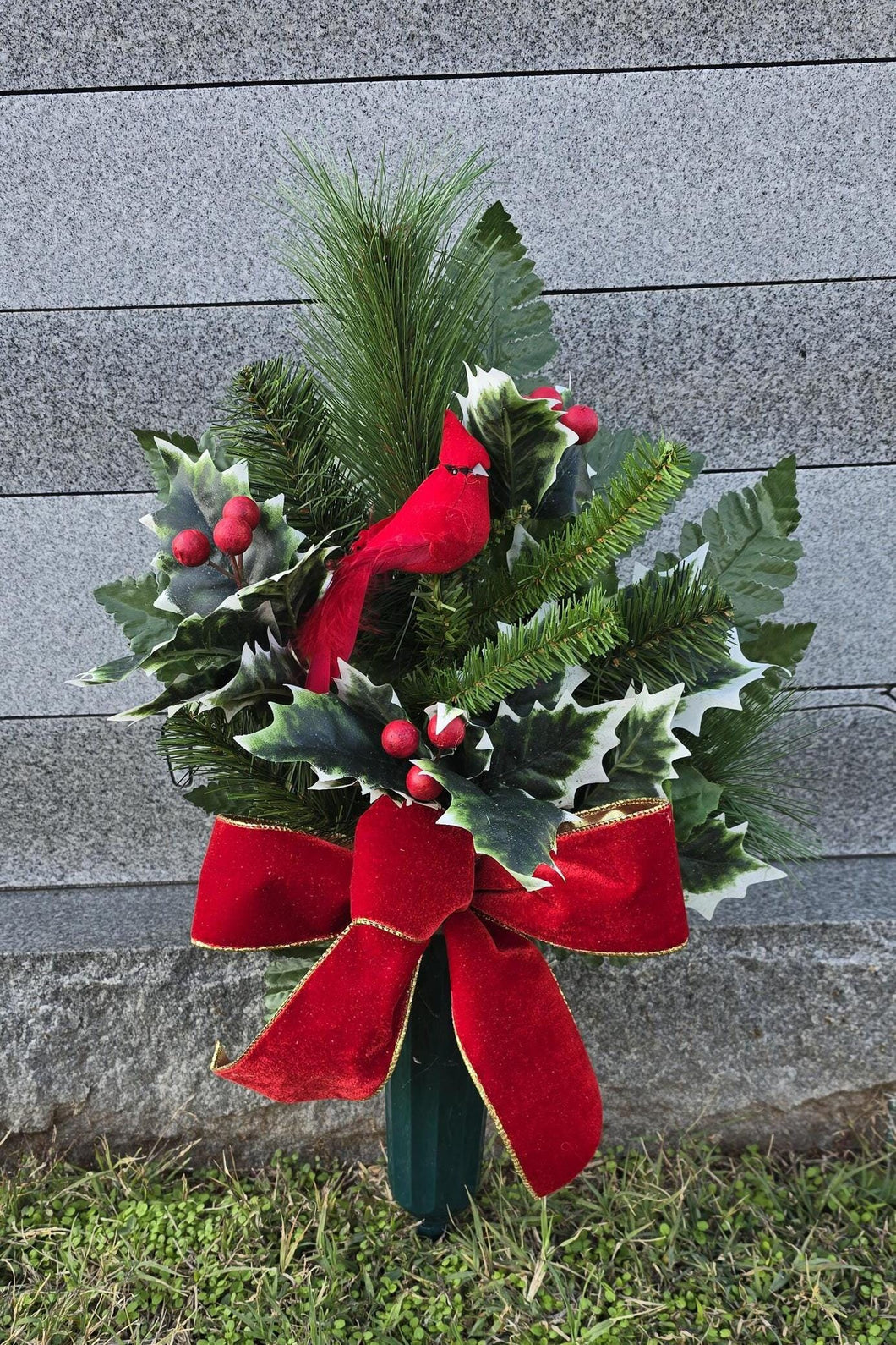 Christmas cemetery vase memorial decoration with berries, holly, and pine.